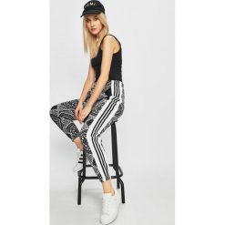 Adidas Originals - Spodnie. Czarne spodnie materiałowe damskie adidas Originals, bez wzorów, z bawełny, casualowe. W wyprzedaży za 199.90 zł.