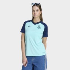 Wyjazdowa koszulka przedmeczowa Niemcy 26. Niebieskie bluzki damskie Adidas, bez wzorów, sportowe, bez kołnierzyka, bez ramiączek. Za 299.00 zł.