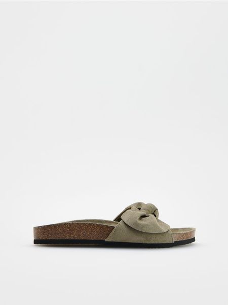 Klapki z kokardami - jasny zielony. Zielone klapki damskie Reserved, bez wzorów, bez obcasa, bez zapięcia. W wyprzedaży za 35.99 zł.