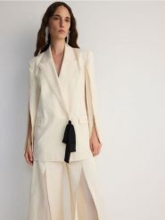 Dwurzędowa marynarka z rozcięciami - kremowy. Białe marynarki i żakiety damskie Reserved, bez wzorów, z bawełny, bez kołnierzyka, bez ramiączek. W wyprzedaży za 279.99 zł.