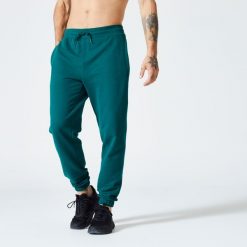 Spodnie dresowe męskie Domyos Gym & Pilates. Niebieskie spodnie sportowe męskie DOMYOS, l, bez wzorów, z bawełny, na fitness i siłownię. Za 99.99 zł.