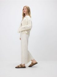Jeansy wide leg z ażurowym wzorem - kremowy. Białe jeansy damskie Reserved, w ażurowe wzory, z bawełny. W wyprzedaży za 109.99 zł.