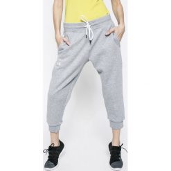 Under Armour - Spodnie. Fioletowe spodnie dresowe damskie Under Armour, z aplikacjami, z bawełny. W wyprzedaży za 139.90 zł.