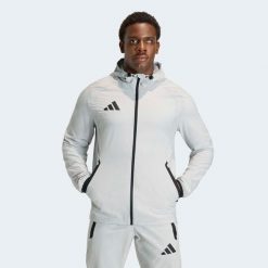 Kurtka piłkarska treningowa ADIDAS Tiro Travel 26. Brązowe kurtki męskie Adidas, s, bez wzorów, z materiału, eleganckie, z kapturem. Za 229.99 zł.