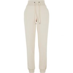 Damskie spodnie dresowe Urban Classics Cozy. Białe spodnie dresowe damskie Urban Classics, bez wzorów, z bawełny, sportowe, długie. Za 244.50 zł.