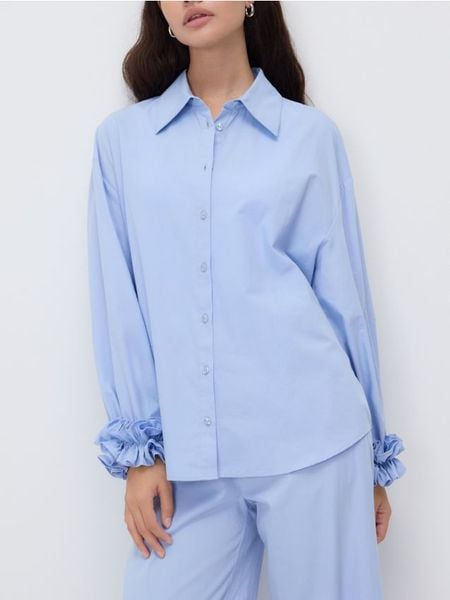 Koszula z dekoracyjną falbaną - jasnoniebieski. Niebieskie koszule damskie Reserved, l, bez wzorów, z bawełny, bez kołnierzyka, bez ramiączek. Za 129.99 zł.