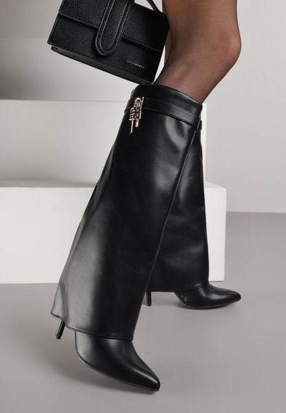 Czarne Kozaki na Szpilce z Cholewką Imitującą Nogawkę z Aplikacją Kłódką Vetidora. Czarne kozaki damskie Born2be, na zimę, z aplikacjami, z materiału, ze szpiczastym noskiem, bez obcasa, na obcasie, bez zapięcia. Za 159.99 zł.