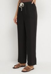 Czarne Spodnie o Szerokim Kroju z Gumką i Wiązaniem w Talii Mirastra. Czarne spodnie dresowe damskie Born2be, bez wzorów, z jeansu, eleganckie, trekkingowe. Za 39.99 zł.