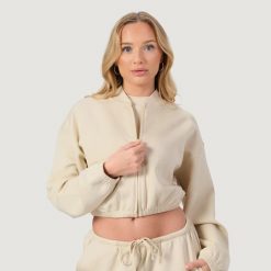 Bluza damska fitness z zamkiem bez kaptura migdałowa NEO. Brązowe bluzy damskie GYMBEAM, l, bez wzorów, z bawełny, sportowe, bez ramiączek, bez kaptura. Za 116.90 zł.