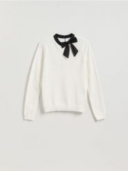 Sweter z ozdobną kokardą - kremowy. Białe swetry nierozpinane damskie Reserved, l, bez wzorów, z dzianiny, bez kołnierzyka, bez ramiączek. Za 109.99 zł.