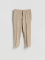 Garniturowe spodnie carrot - beżowy. Brązowe garnitury męskie Reserved, bez wzorów, z tkaniny. Za 169.99 zł.