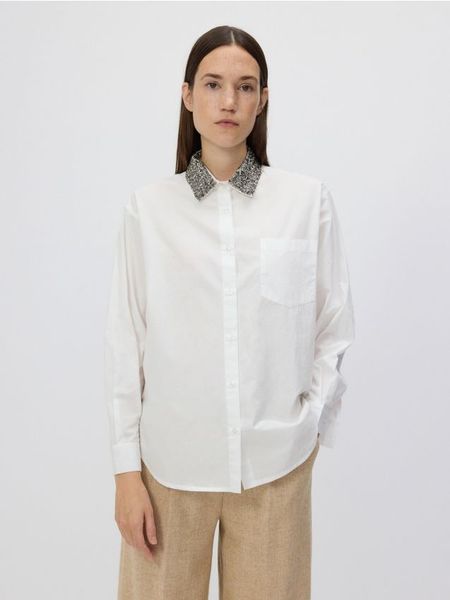 Koszula z ozdobnym kołnierzem - biały. Białe koszule damskie Reserved, l, bez wzorów, z bawełny, bez kołnierzyka, bez ramiączek. W wyprzedaży za 59.99 zł.