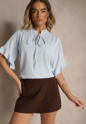 Jasnoniebieska Bluzka z Falbanami i Wiązaniem Fadeassa. Niebieskie bluzki damskie Renee, bez wzorów, bez kołnierzyka, bez ramiączek. Za 44.99 zł.