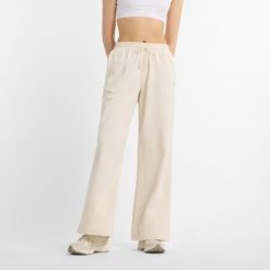 Spodnie damskie New Balance WP51503LIN – beżowe. Brązowe spodnie materiałowe damskie New Balance, z aplikacjami, z bawełny, klasyczne. Za 359.99 zł.