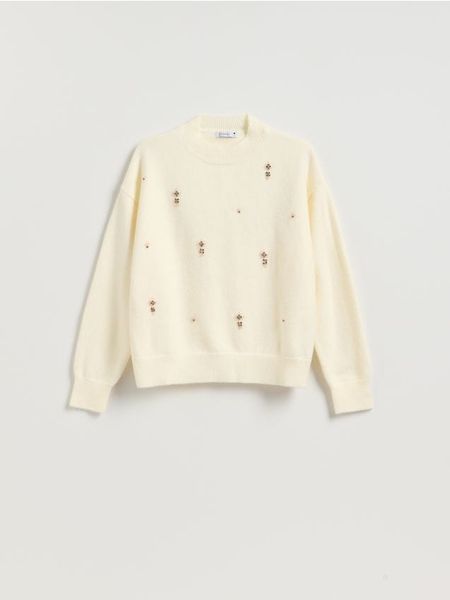 Sweter z ozdobnymi aplikacjami - kremowy. Białe swetry nierozpinane damskie Reserved, l, z aplikacjami, z dzianiny, bez kołnierzyka, bez ramiączek. Za 139.99 zł.