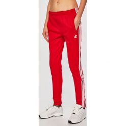Adidas Originals - Spodnie. Czerwone spodnie materiałowe damskie adidas Originals, bez wzorów, z bawełny, casualowe. Za 199.90 zł.