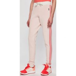 Adidas Performance - Spodnie. Czerwone spodnie materiałowe damskie adidas Performance, bez wzorów, z materiału, casualowe. W wyprzedaży za 279.90 zł.
