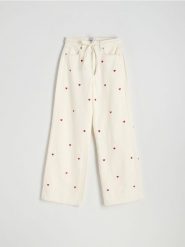 Jeansy wide leg z haftowanym wzorem - biały. Białe jeansy damskie Reserved, bez wzorów, z bawełny. W wyprzedaży za 109.99 zł.