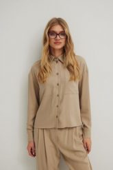 Koszula o prostym kroju z kieszonką w kolorze STONE BEIGE - ROMA-M/L. Brązowe koszule damskie Marsala, l, bez wzorów, z tkaniny, eleganckie, bez kołnierzyka, bez ramiączek. Za 299.90 zł.