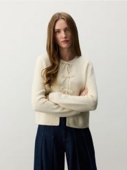 Kardigan z kokardami - kremowy. Białe kardigany damskie Reserved, l, bez wzorów, z dzianiny, bez kołnierzyka. W wyprzedaży za 119.99 zł.