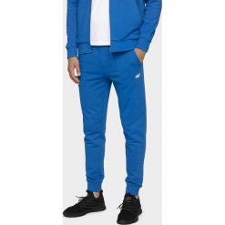 Spodnie dresowe męskie SPMD300 - niebieski. Niebieskie spodnie sportowe męskie 4F, m, bez wzorów, z dresówki. Za 119.99 zł.