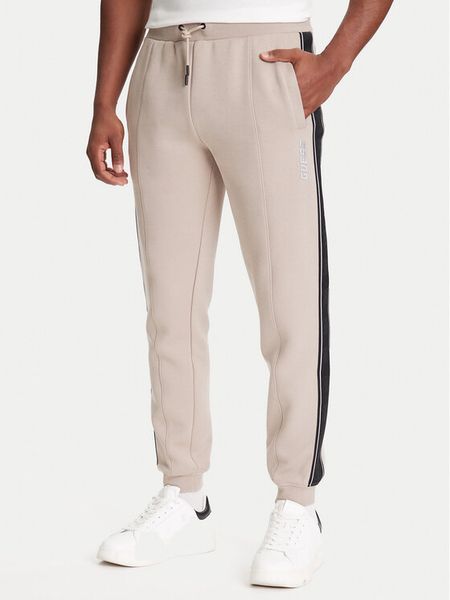 Guess Spodnie dresowe Z2YB09 KB3P2 Beżowy Regular Fit. Brązowe spodnie sportowe męskie Guess, m, z aplikacjami, z bawełny. Za 239.99 zł.