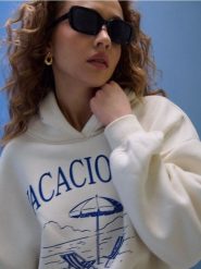 Dresowa bluza hoodie z nadrukiem "Vacaciones" - kremowy. Białe bluzy damskie Sinsay, l, bez wzorów, z dresówki, bez ramiączek, bez kaptura. Za 49.99 zł.