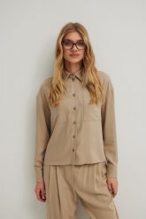 Koszula o prostym kroju z kieszonką w kolorze STONE BEIGE - ROMA. Brązowe koszule damskie Marsala, m, bez wzorów, z tkaniny, eleganckie, bez kołnierzyka, bez ramiączek. Za 299.90 zł.