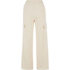 Damskie spodnie dresowe loose fit Urban Classics. Białe spodnie dresowe damskie Urban Classics, bez wzorów, z bawełny, sportowe, długie, do biegania. Za 182.50 zł.