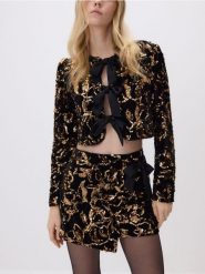 Cekinowa marynarka z kokardami - czarny. Czarne marynarki i żakiety damskie Reserved, bez wzorów, z dzianiny, bez kołnierzyka, bez ramiączek. Za 179.99 zł.