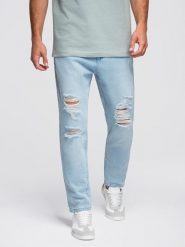 Spodnie jeansowe męskie CARROT FIT z przetarciami – jasnoniebieskie V1 - Rozmiar: XXL. Niebieskie spodnie materiałowe męskie Ombre Clothing, z aplikacjami, z bawełny. W wyprzedaży za 191.99 zł.