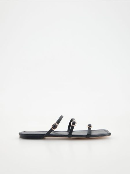 Skórzane klapki - czarny. Czarne klapki damskie Reserved, bez wzorów, ze skóry, klasyczne, bez obcasa, bez zapięcia. W wyprzedaży za 49.99 zł.