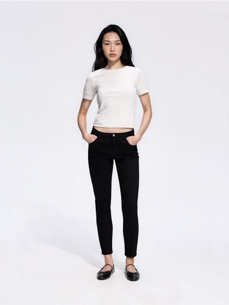 Jeansy slim fit - czarny. Czarne jeansy damskie Reserved, bez wzorów, z bawełny. Za 99.99 zł.