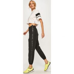 Reebok - Spodnie. Czarne spodnie dresowe damskie Reebok, bez wzorów, z materiału, sportowe. Za 179.90 zł.
