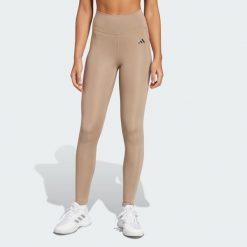 Długie legginsy Optimé Essentials Stash Pocket. Brązowe legginsy damskie Adidas, bez wzorów, z elastanu. Za 204.20 zł.