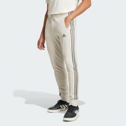 Spodnie Essentials French Terry Tapered Cuff 3-Stripes. Szare spodnie sportowe męskie Adidas, s, bez wzorów, z dresówki, na jogę i pilates. W wyprzedaży za 157.65 zł.