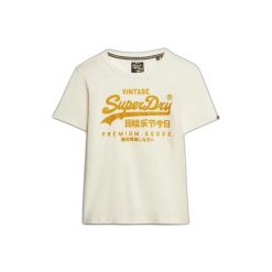 T-shirt z fantazyjnym logo dla kobiet Superdry Vintage. Białe t-shirty damskie Superdry, bez wzorów, vintage, bez kołnierzyka, bez ramiączek. W wyprzedaży za 144.00 zł.