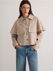 Trencz z peleryną - kremowy. Białe płaszcze damskie Reserved, l, bez wzorów, z bawełny, bez kołnierzyka, bez kaptura. W wyprzedaży za 119.99 zł.