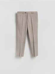 Garniturowe spodnie carrot - brązowy. Brązowe garnitury męskie Reserved, bez wzorów, z tkaniny. Za 169.99 zł.