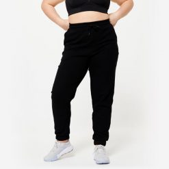 Spodnie dresowe damskie Domyos Gym & Pilates. Czarne spodnie dresowe damskie DOMYOS, bez wzorów, z bawełny, sportowe. Za 89.99 zł.