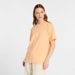 Koszulka damska New Balance WT41501PAE – pomarańczowa. Brązowe bluzki damskie New Balance, m, bez wzorów, z materiału, eleganckie, bez kołnierzyka, bez ramiączek. Za 69.99 zł.