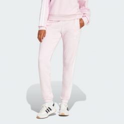 Spodnie Essentials 3-Stripes French Terry Cuffed. Białe spodnie dresowe damskie Adidas, bez wzorów, z materiału, sportowe. W wyprzedaży za 131.40 zł.