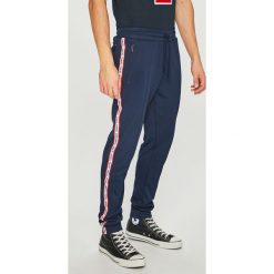 Tommy Jeans - Spodnie. Niebieskie spodnie materiałowe męskie Tommy Jeans, bez wzorów, z bawełny. W wyprzedaży za 259.90 zł.